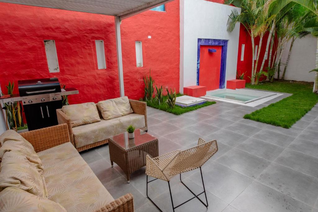 里韦拉Hotel Casa David的一个带沙发和椅子的庭院和红色的墙壁