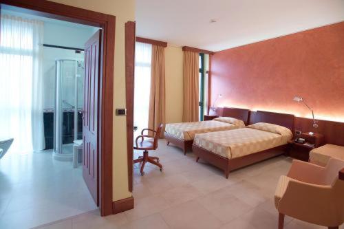 卡尔马尼奥拉艾尔伯格圣马可餐厅酒店的一间卧室设有两张床和滑动玻璃门