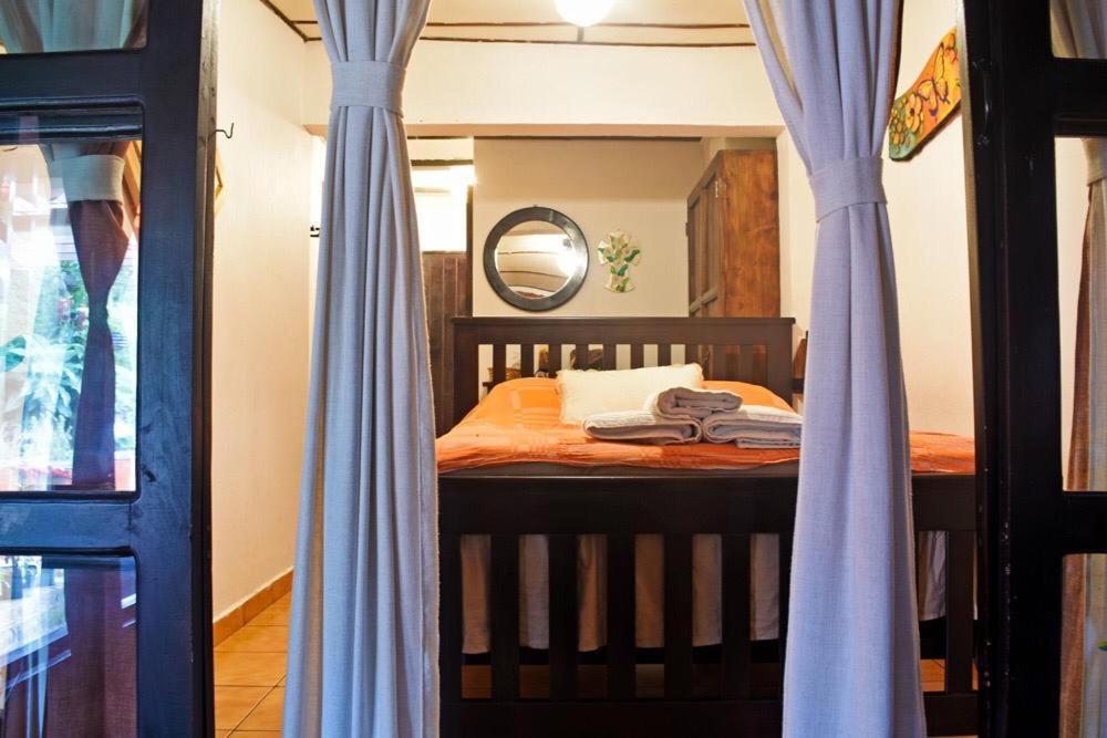 ApanecaHostal Santa Clara B&B的一间卧室配有一张带蓝色窗帘和镜子的床