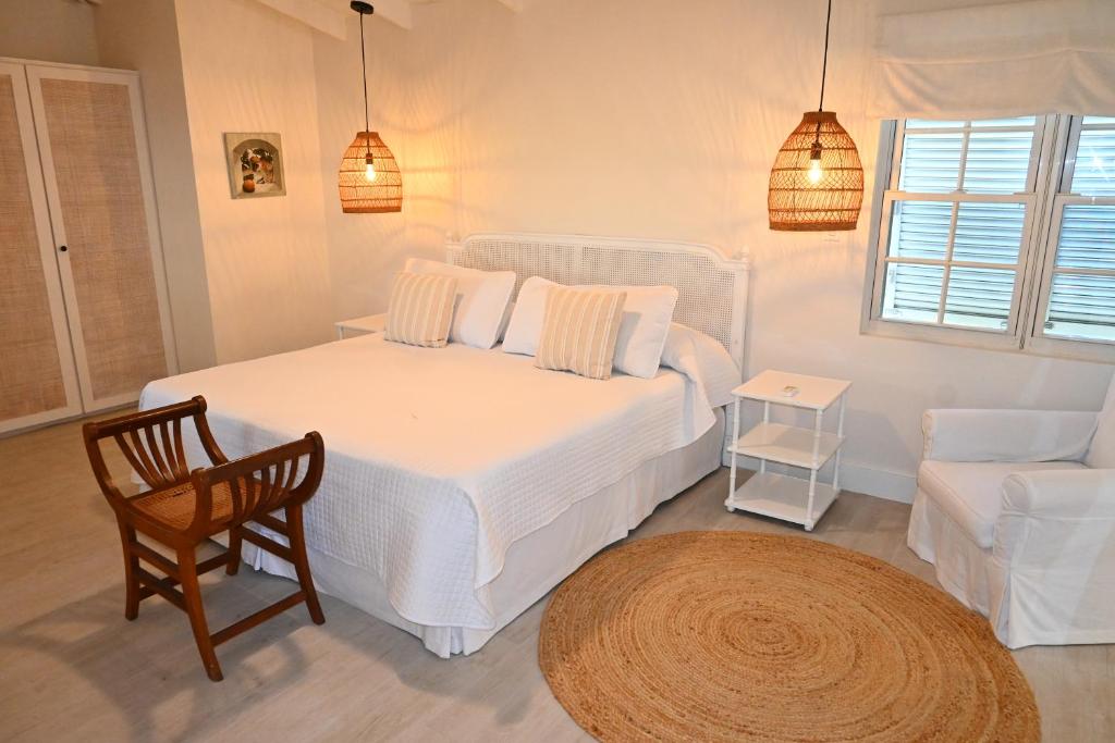圣彼得教区小古德港酒店的卧室配有白色的床、椅子和沙发