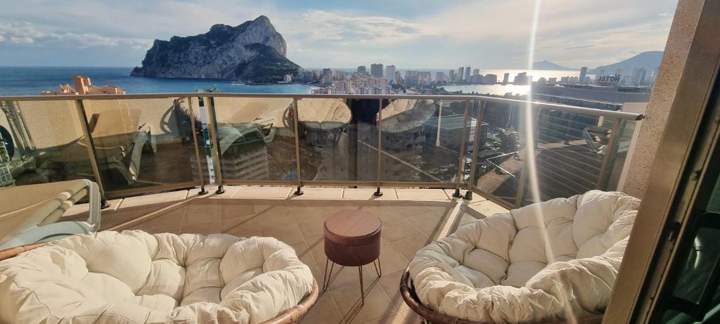卡尔佩Esmeralda Suites Sunrise的阳台配有白色椅子,享有海景。