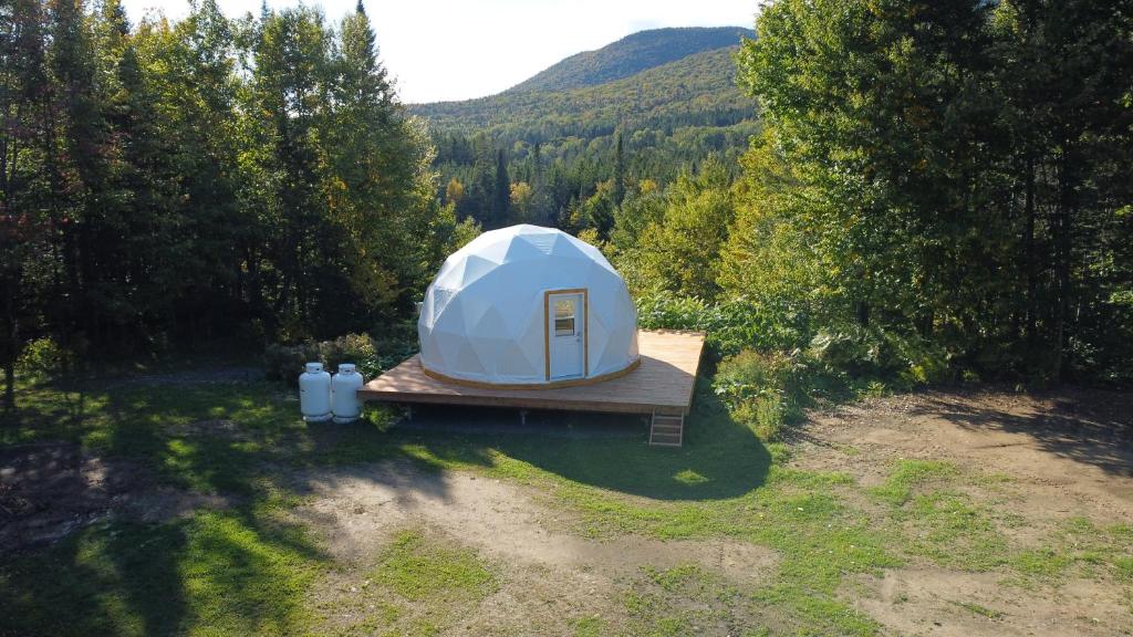 圣加布里尔德瓦尔卡捷Vallée Jeunesse Québec的田野木平台上的白色帐篷