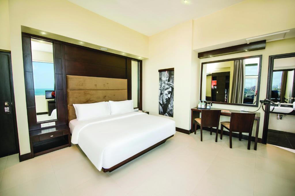科伦坡科伦坡美景酒店的卧室配有一张白色的大床和一张桌子
