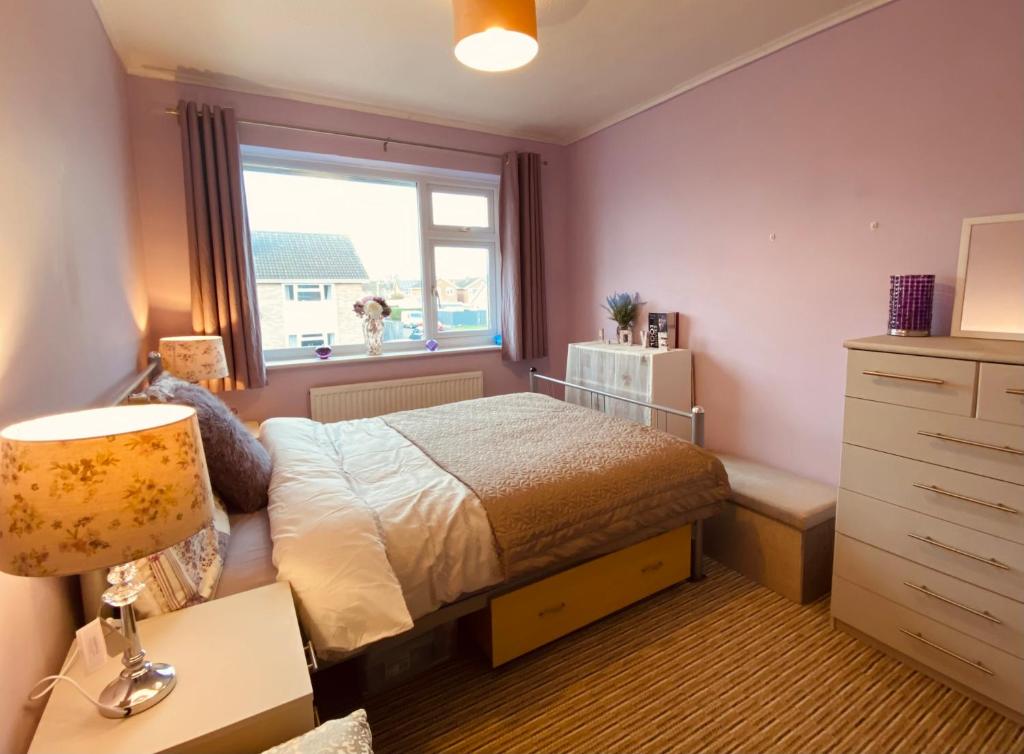 切尔滕纳姆Purple dream double bedroom的一间卧室设有一张床和一个窗口