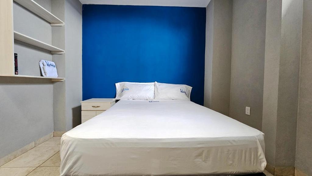 提瓦坎Sensity Home Recamara moderna的蓝色墙壁间的一张床位