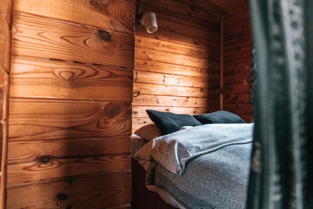 胡萨维克Kaldbaks-kot cottages的一间带木墙的卧室和一张位于客房内的床