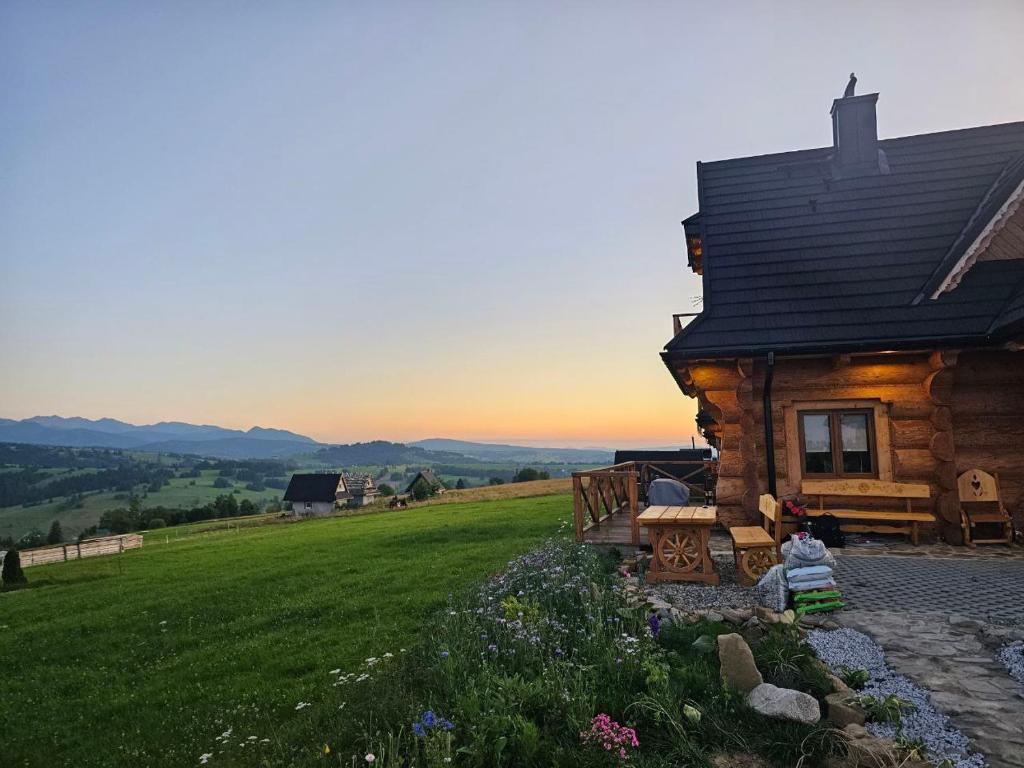 CzerwienneMountain View Chalet with HotTub and Sauna的小木屋,位于郁郁葱葱的绿色田野顶部