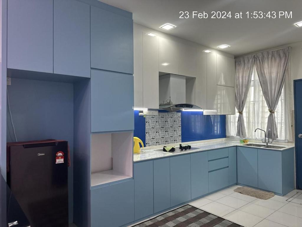 Kampung SeelungML Homestay的蓝色和白色的厨房配有水槽和冰箱