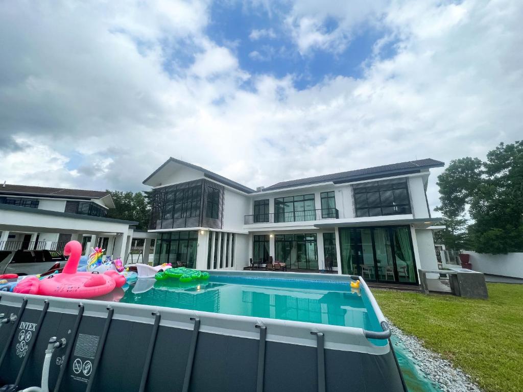 新山Desaru 20Pax Cozy Chill villa Private Pool的房屋前有游泳池的房子