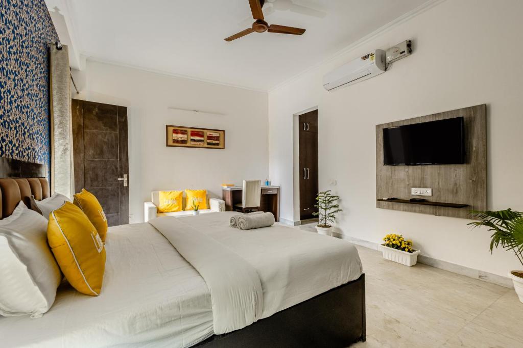 古尔冈Lime Tree Hotel - Golf Course Road, Sector-43, Gurugram的卧室配有一张带黄色枕头的大型白色床。