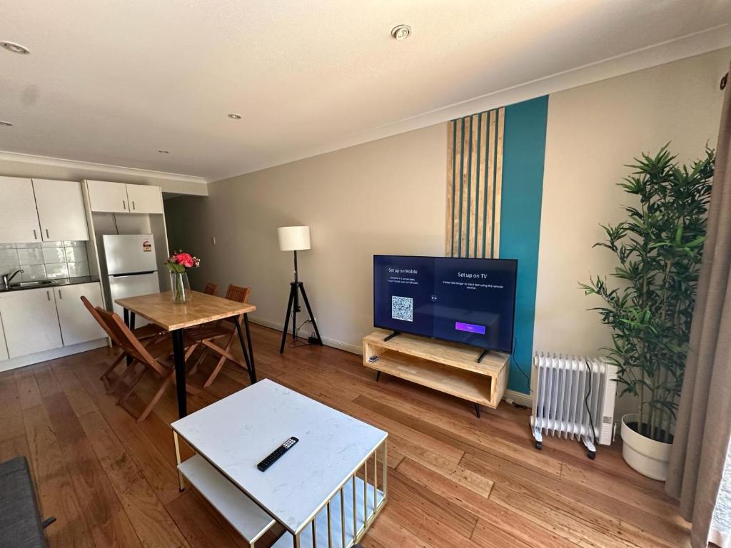 悉尼Elegant 2 Bedroom home close to city buz Bridge RD 2 E-Bikes Included的一间带电视和桌子的客厅