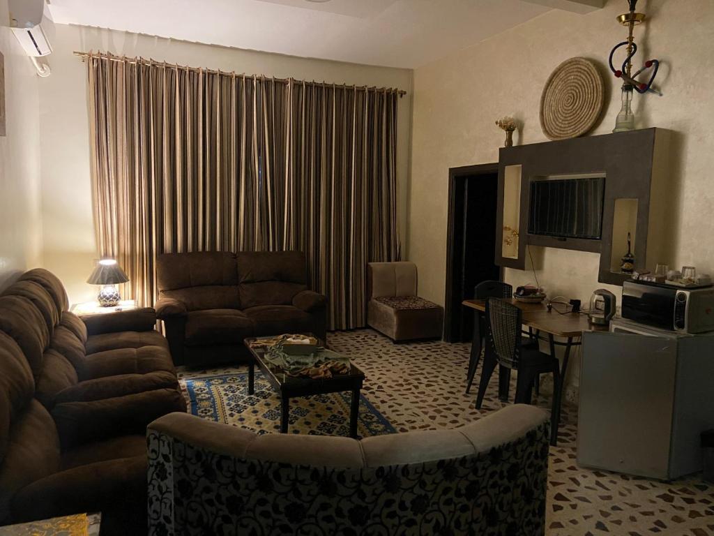 马达巴Madaba Mesha Stele Bedoiun Apartments的客厅配有沙发和桌子