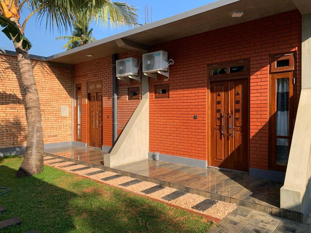 塞杜瓦Airport Colombo Pocket Paradise的棕色门和棕榈树的砖砌建筑