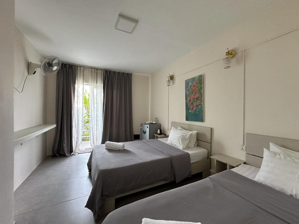 西哈努克Ginger Sihanoukville的酒店客房设有两张床和窗户。