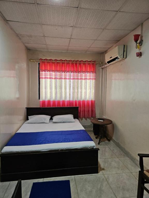 KilinochchiHotel SELLA & Rest的一间卧室配有床和红色窗帘