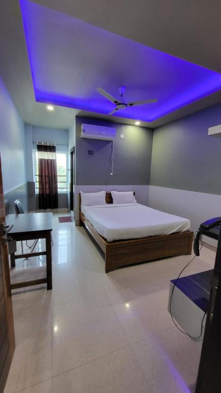 北拉欣布尔HOTEL NAHAR的一间卧室配有一张紫色天花板的床