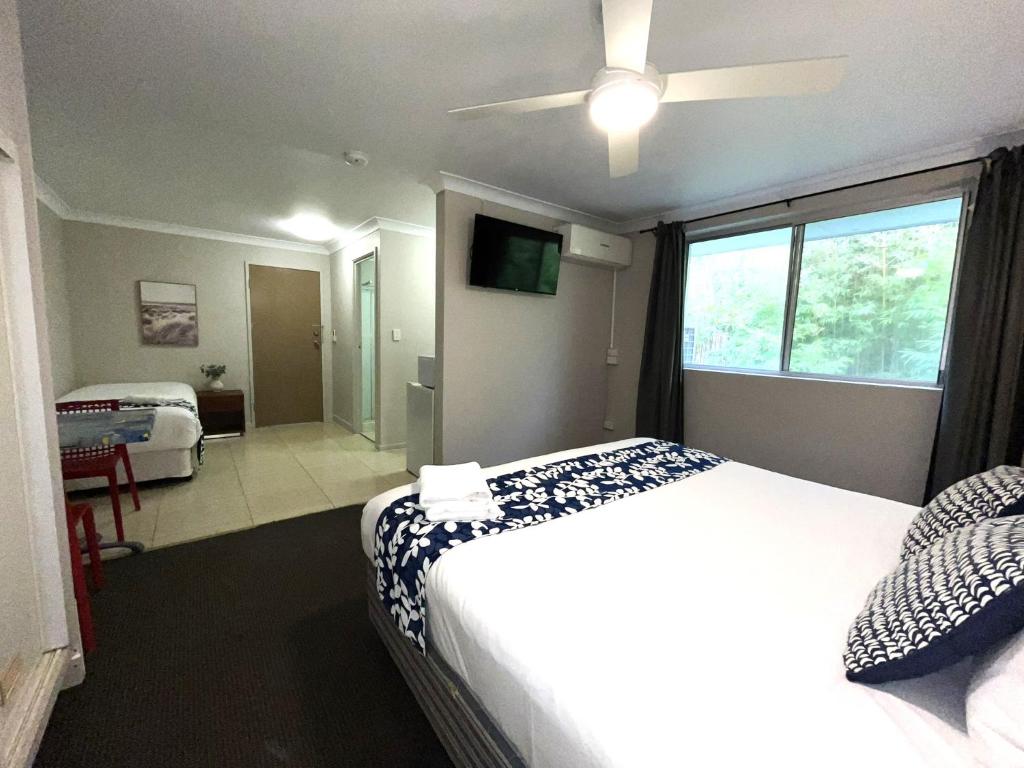 黄金海岸Browns Broadbeach的一间卧室配有一张床和吊扇