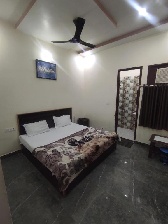 马图拉Nidhivan Nivas的一间卧室配有一张床和吊扇