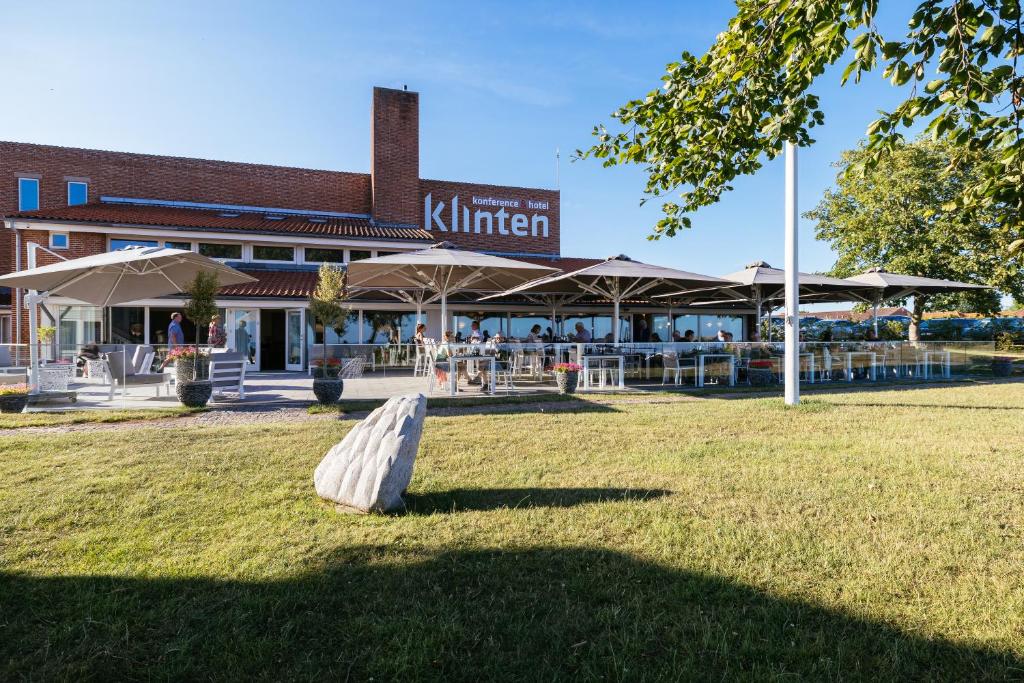 勒兹维Hotel Klinten的建筑物前草上的长凳