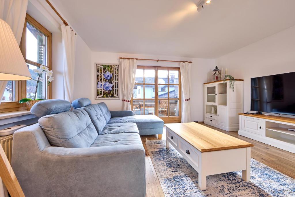 加尔米施-帕滕基兴AlpenZauber的客厅配有蓝色的沙发和桌子