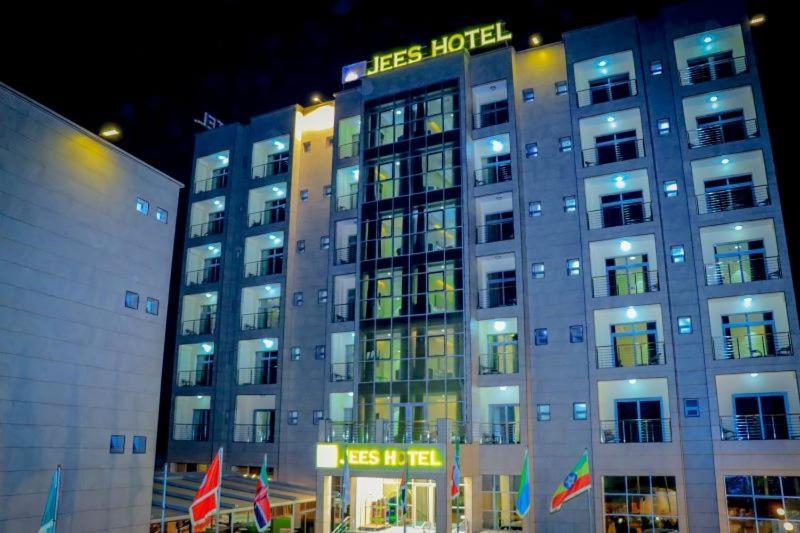 哈尔格萨Jees Hotel的夜间标有标志的酒店大楼