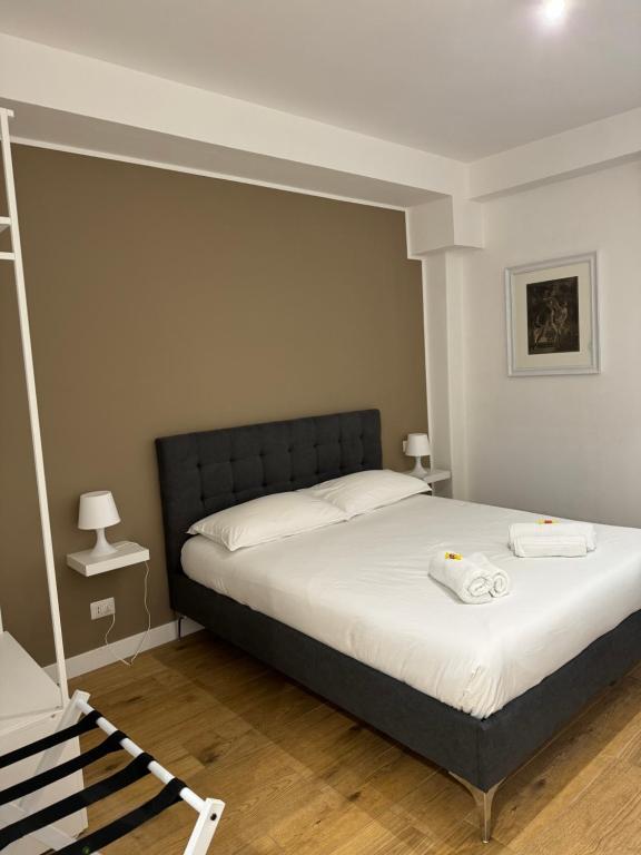 罗马Titina Suites Apartment Rome的一间卧室配有一张床,上面有两条毛巾