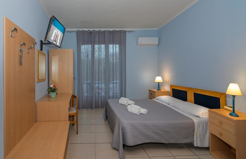 维亚雷焦Hotel Villa Benvenuti的酒店客房,配有床和电视