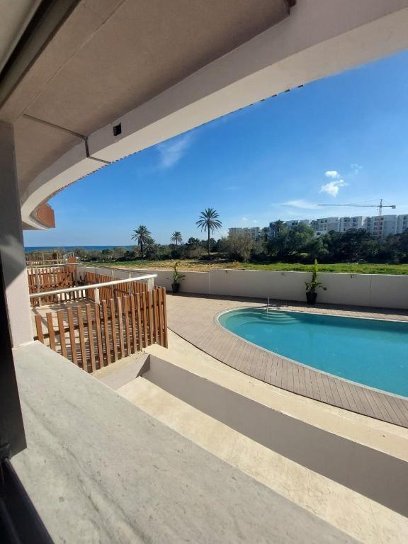 El AhmarThe Wave residence Chott Meriam Sousse的从房子里可欣赏到游泳池的景色