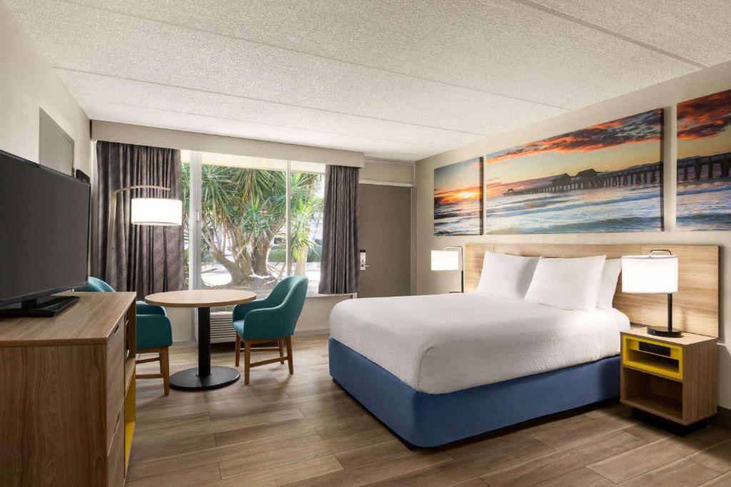 可可比奇可可比奇戴斯酒店的配有一张床、一张桌子和一张桌子的酒店客房
