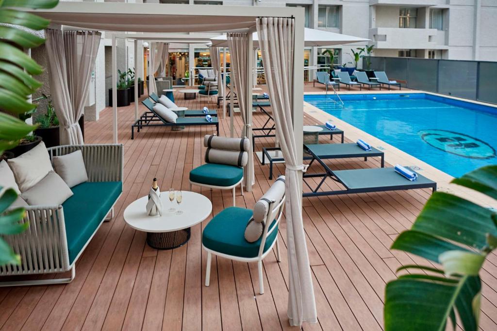 珀斯珀斯帕米利希尔顿酒店的一个带椅子的甲板和一个游泳池