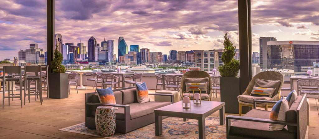 达拉斯Canopy By Hilton Dallas Uptown的一个带桌椅的屋顶露台,享有城市天际线