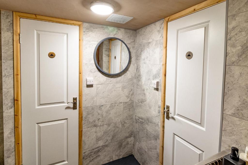 CwmcarnCwmcarn Hotel & Bunkhouse的浴室设有白色门和镜子