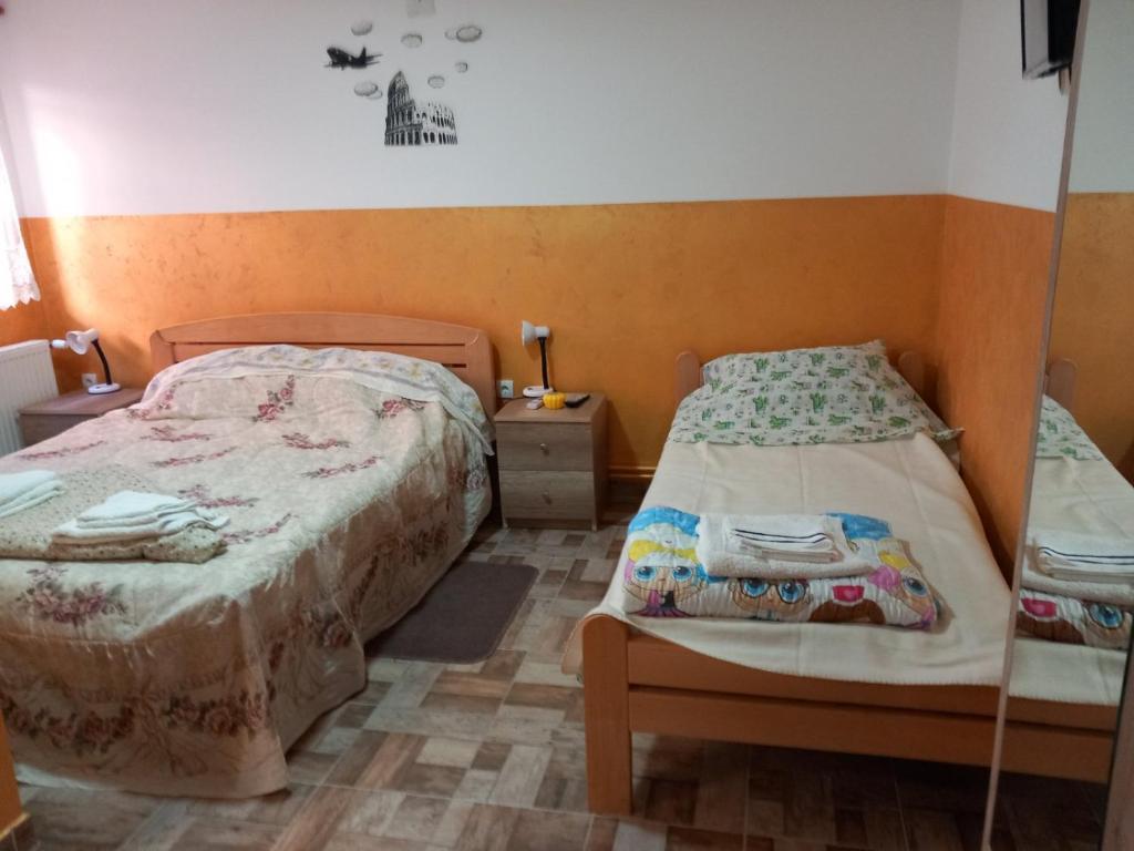 大格拉迪什泰Sobe Viktorija的一间卧室配有两张床、床头柜和床套