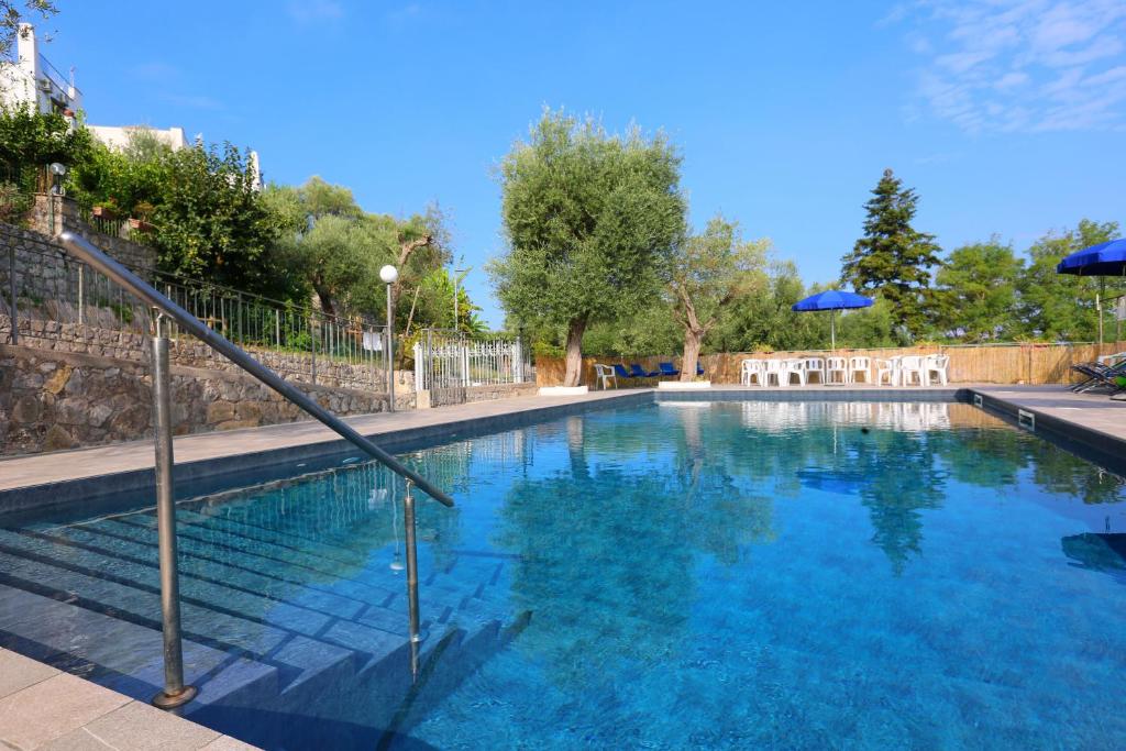 索伦托AMORE RENTALS - Villa Tittina的一座带蓝色水和遮阳伞的大型游泳池
