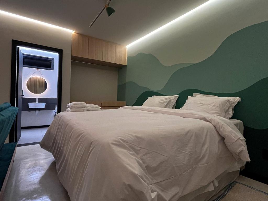 皮乌米Theotokos Flats Apart-hotel的一间卧室配有一张白色的床和绿色的墙壁