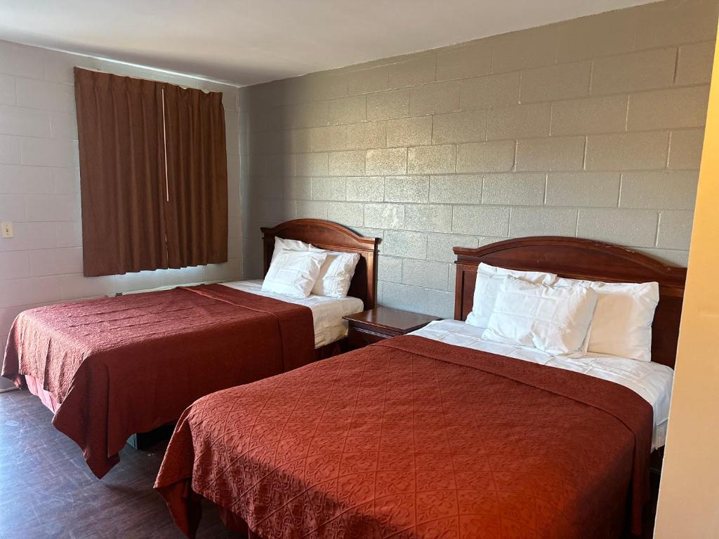 伯明翰Sky Inn Hotel的酒店客房,配有两张带红色床单的床