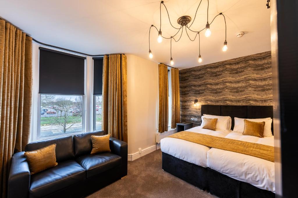 利物浦Home @ Arkles Lane的一间卧室配有一张床、一张沙发和一个窗口
