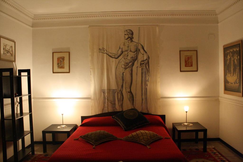 雷焦卡拉布里亚B&B degli Ottimati的卧室配有红色的床,墙上挂着雕像