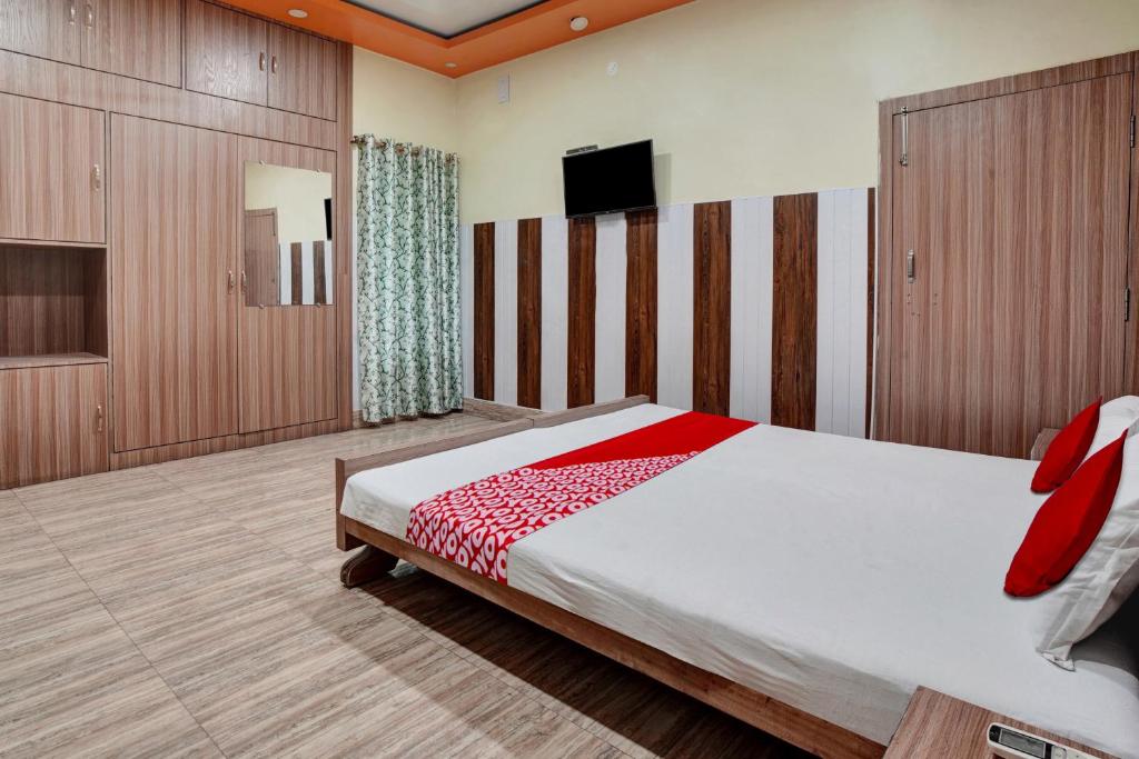 巴特那OYO Flagship Om Shriyam Banquet And Heritage的一间卧室配有一张床和一台平面电视