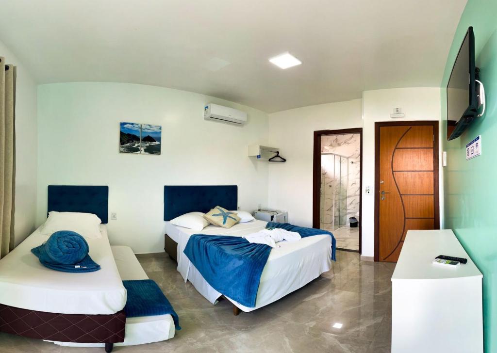 佩尼亚Pousada Mar de Luna的一间卧室设有两张床,一扇门通往房间