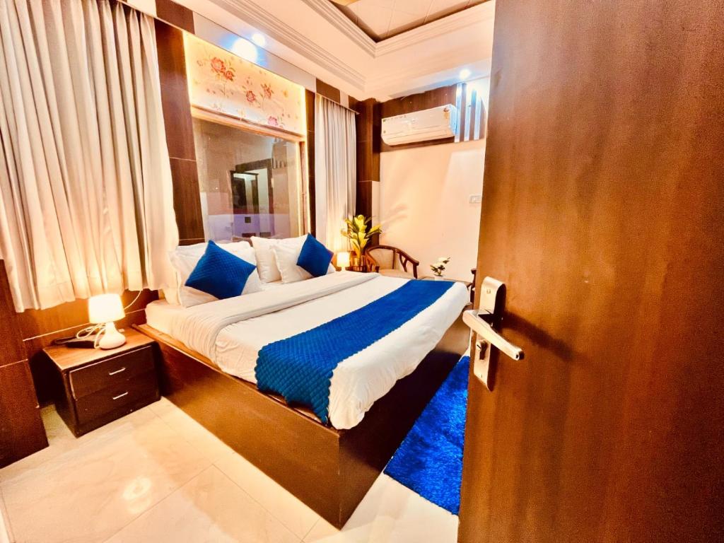 哈里瓦Hotel Ramawati - A Luxury Hotel In Haridwar的一间卧室配有一张带蓝色枕头的大床