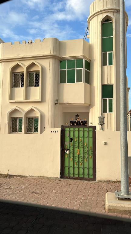 马斯喀特Basil Hostel的前面有一道绿门的建筑