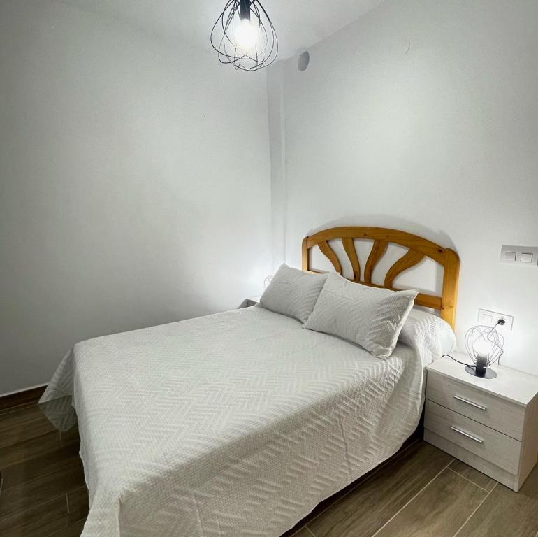 PuertoBajo Derecha el Wiro的卧室配有白色的床和床头柜
