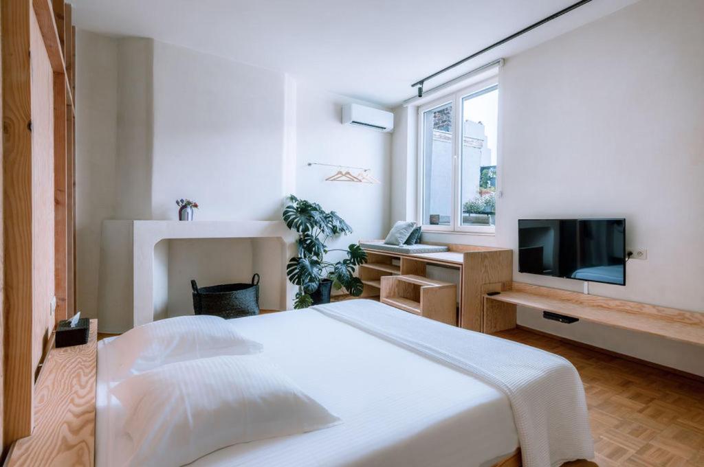 根特Violet Suites的白色卧室设有一张大床和电视。