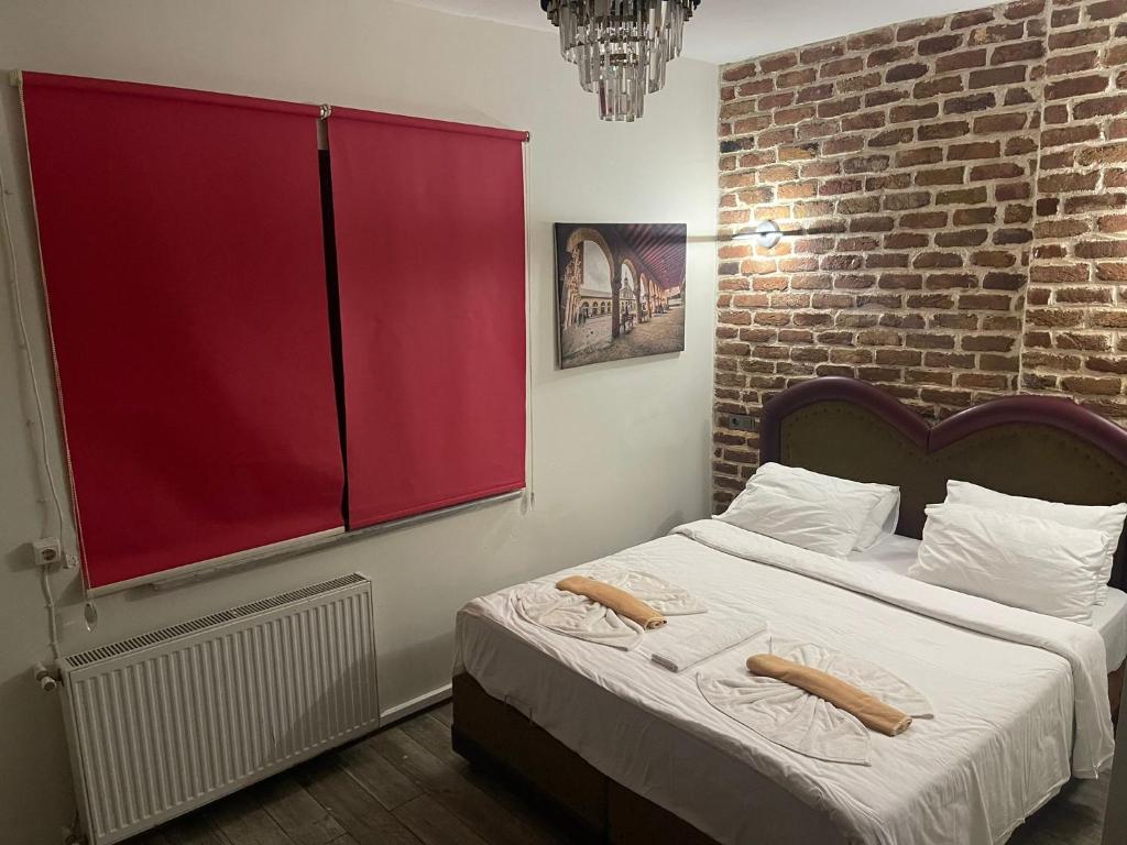 伊斯坦布尔GRAND BELLA VİSTA Hostel的一间卧室设有一张大床和红色窗户