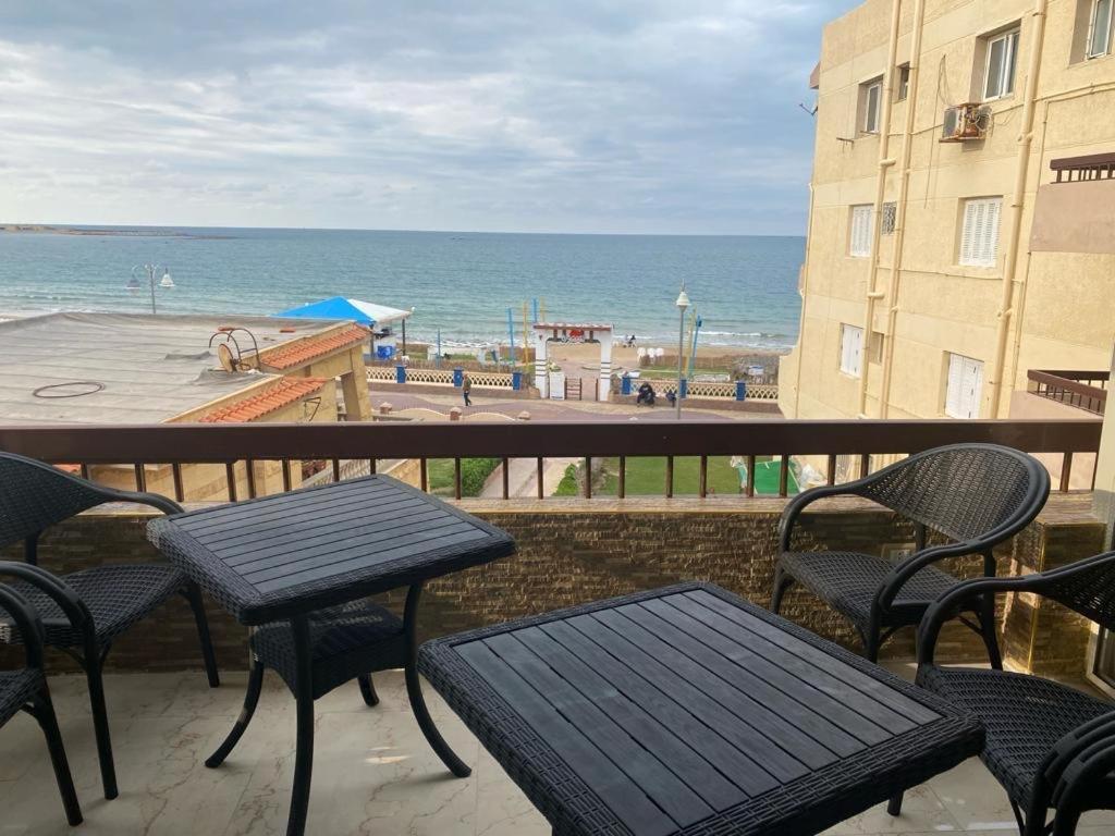 亚历山大Maxeem Direct sea view Apartment super Lux 2 bed rooms Maamoura Beach شاليه سوبر لوكس مجموعه مكسيم شاطىء المعموره على البحرمع كارنيهات بوابه طول السنه و الشاطىء الخاص من اول مايو الى نهايه اكتوبر للعائلات的一个带桌椅的海景阳台