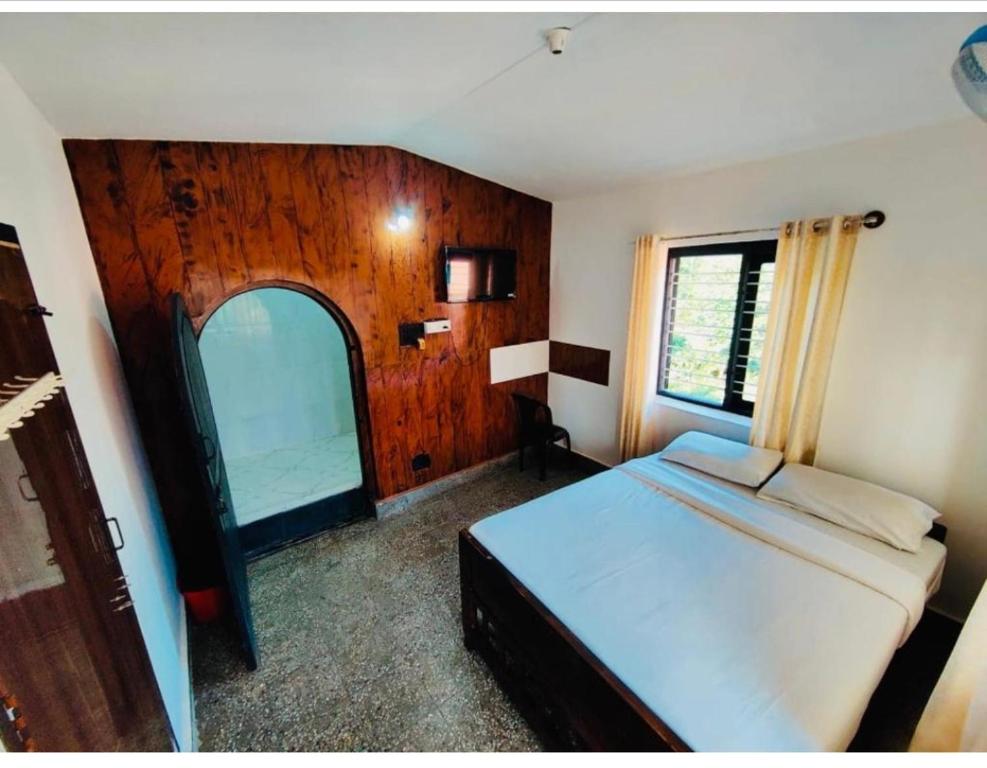 马迪凯里Streaming Valley Independent Coffee Estate Stay的一间卧室设有一张床和一个大窗户