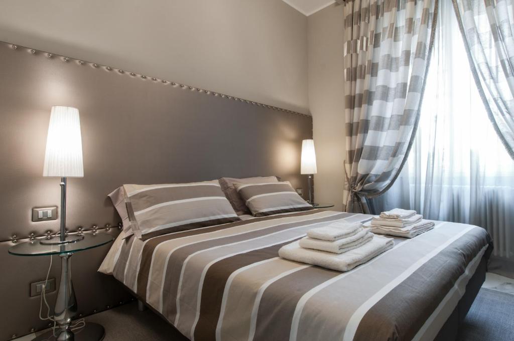 米兰布雷拉名誉住宿加早餐旅馆的一间卧室配有带毛巾的床