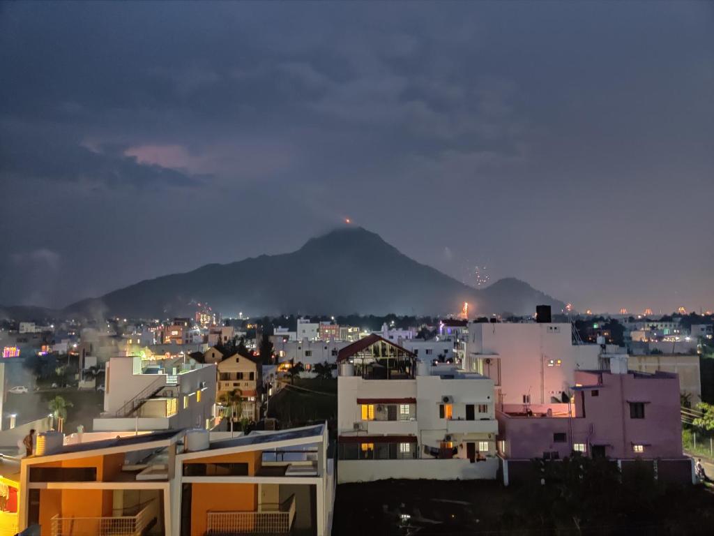 蒂鲁瓦纳马莱Wind Chimes的一座夜晚的城市,以山为背景