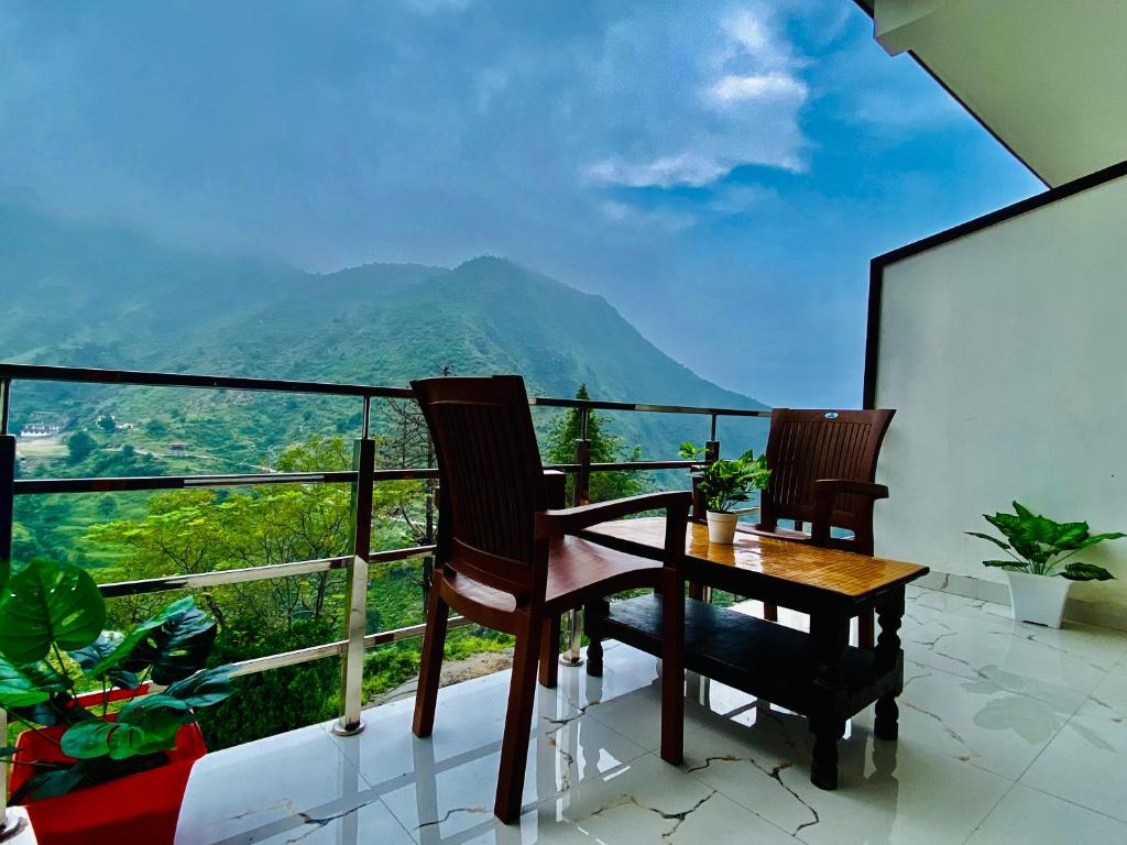 穆索里The Four Season Resort - Top Rated & Most Awarded Property in Mussoorie的设有一个配有桌椅并享有美景的阳台。